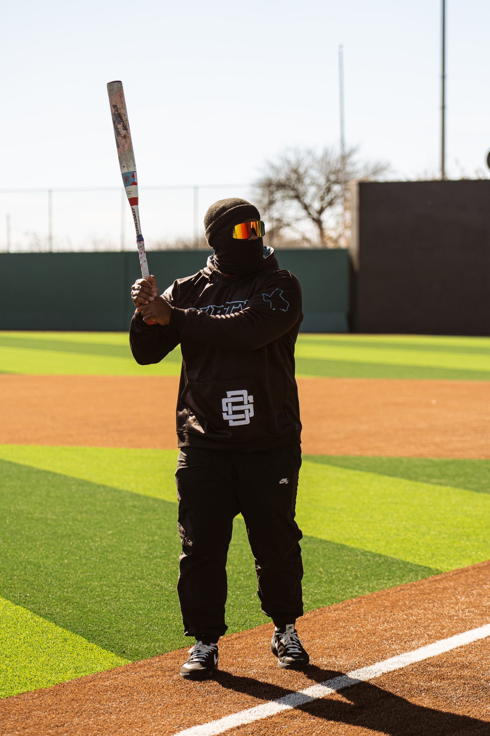 DSC07762 A smiling young girl kicks a soccer ball toward a goal on a turf field at a youth soccer camp.